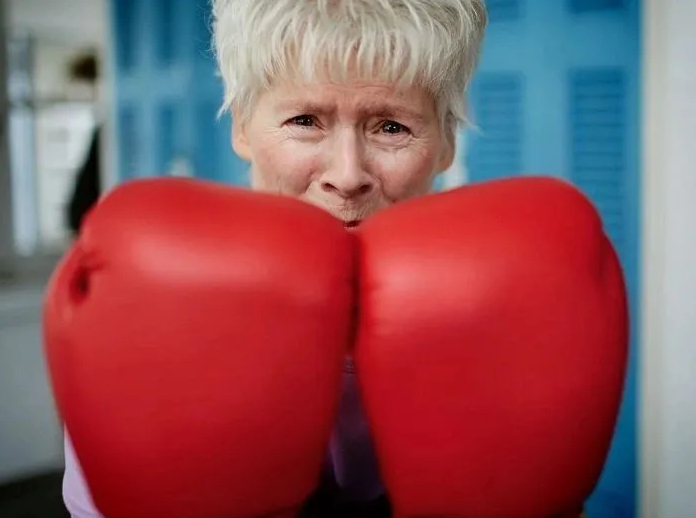 Rock Steady Boxing Thousand Oaks participant boxing with red gloves